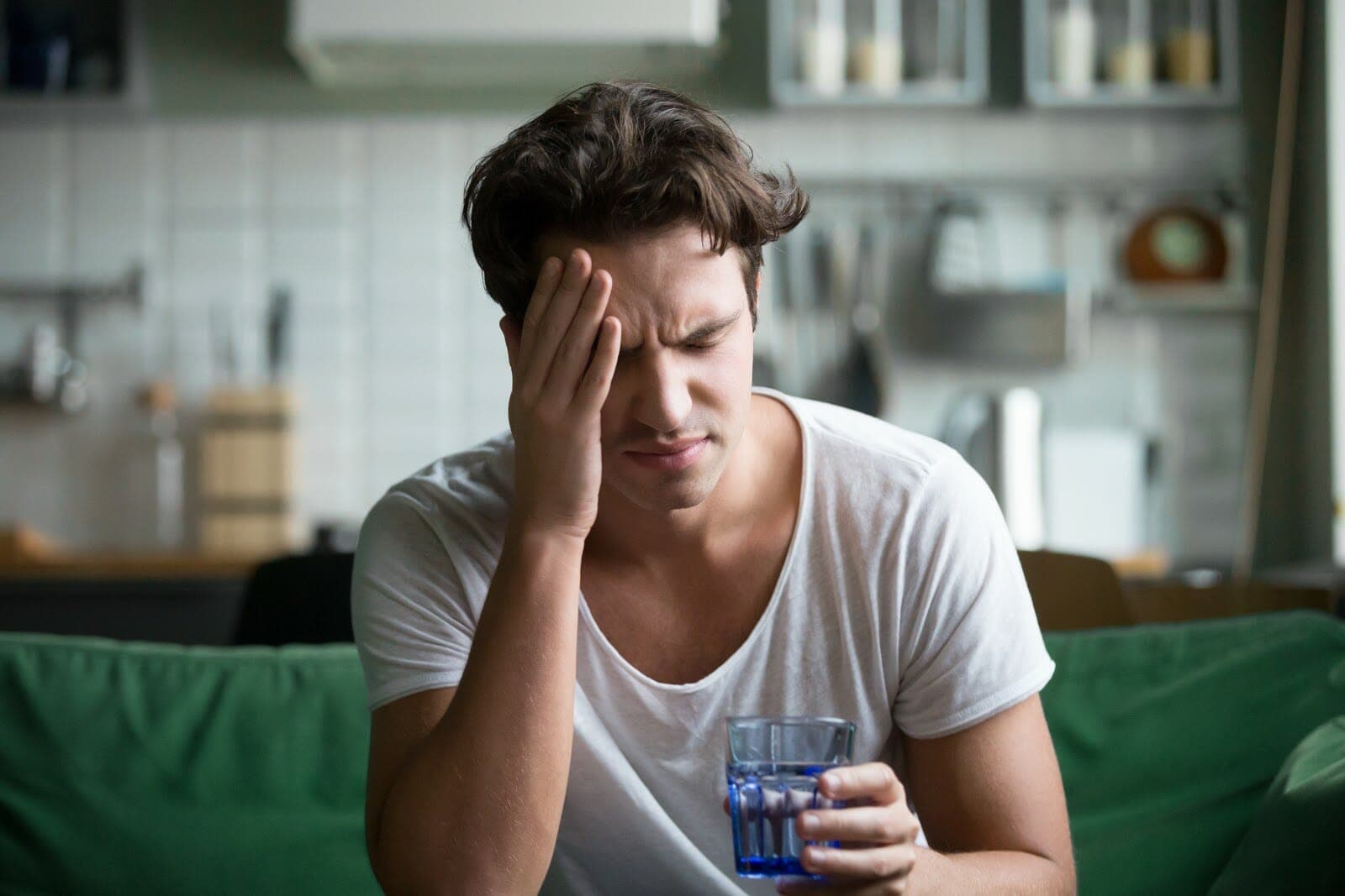 ill man holding a glass of drinking water