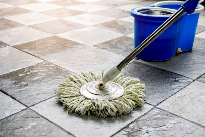 Cleaning patio floor using a mop and bucket for water efficiency