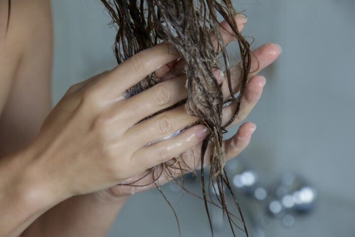 Hands moisturizing hair after washing with hard water