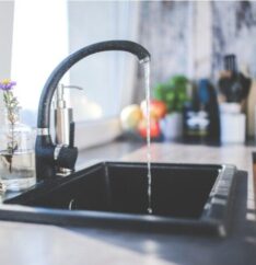 Flowing tap water highlighting the need for water softening, filtration, or purification