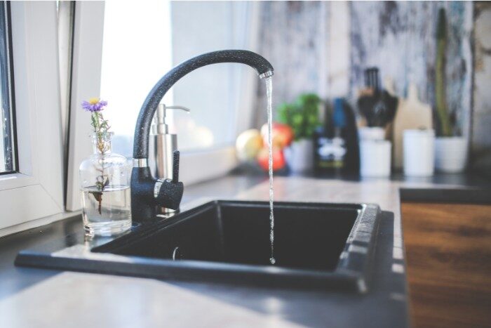 Flowing tap water highlighting the need for water softening, filtration, or purification