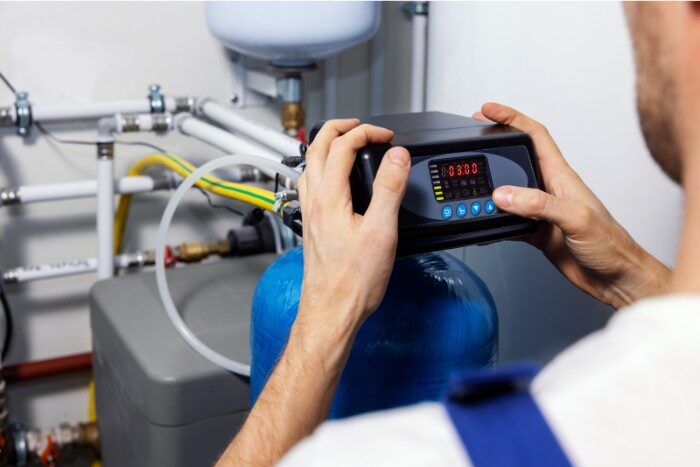 Technician programming a whole-house water softener system