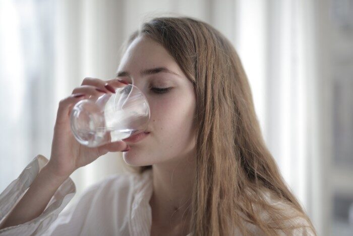 Woman enjoying low-sodium water in a Phoenix home from salt-free water softener and RO system