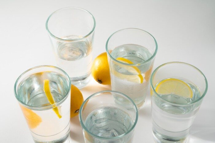Clean filtered water with lemon slices in clear glasses