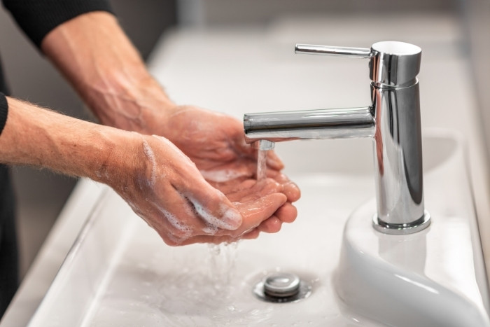 Hands washing at sink showing reduced soft water feel from low salt
