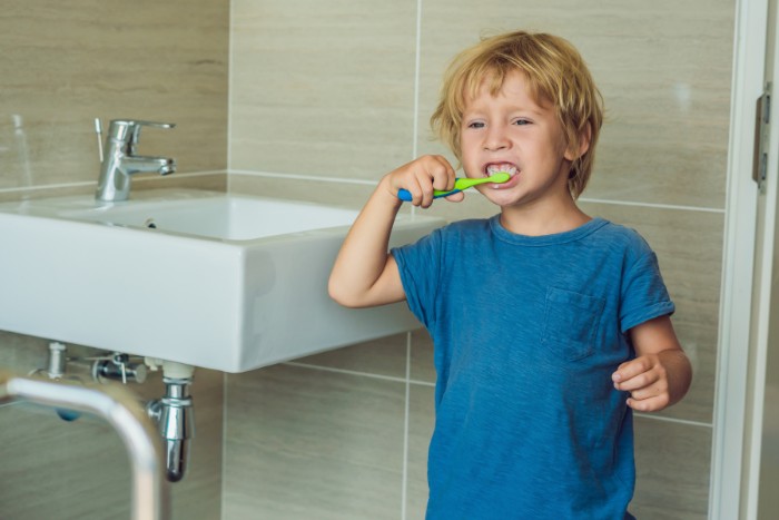 Child brushing teeth in a Phoenix bathroom where hard water is common