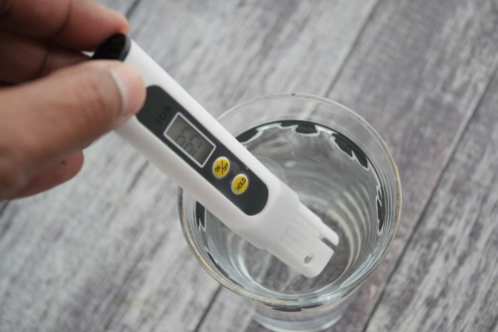 Digital TDS tester checking total dissolved solids in water