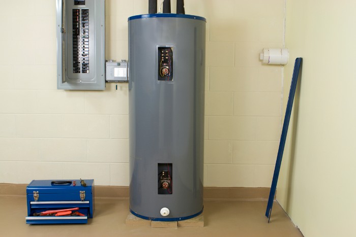 Residential water heater installed in a utility room with nearby tools