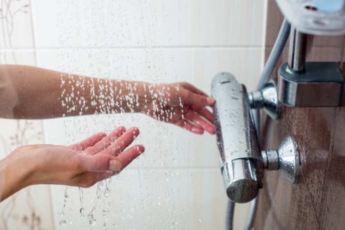Arizona homeowner testing softened hot water from a shower head