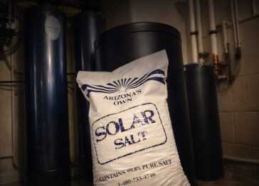 Solar salt bag leaning beside brine tank and water softener system