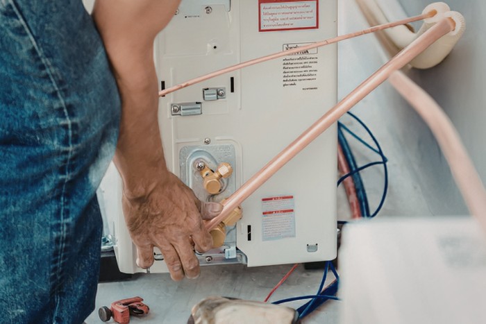 Technician servicing water heater during maintenance